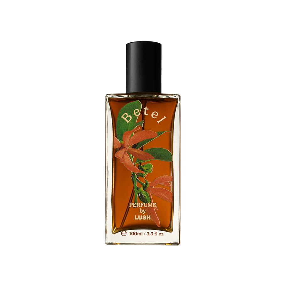 Betel. A rectangular, glass perfume bottle with a black cap is filled with translucent, deep-amber liquid. The name "Betel" is arched in gold letters on the front of the bottle along with flower decals.
