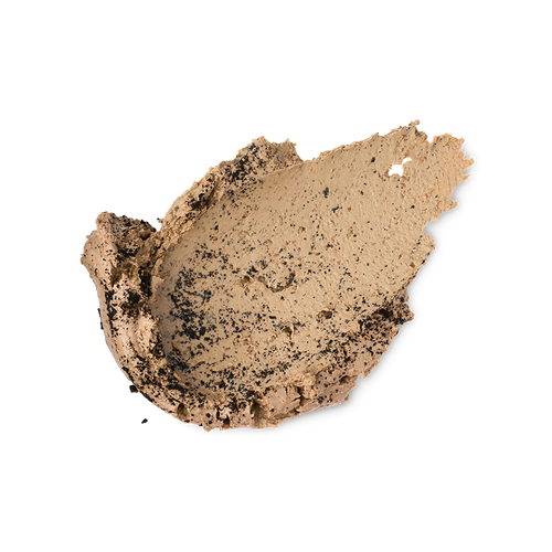 A textured swipe of Black Tea Mochi face mask on a light gray background. The thick, creamy beige formula is heavily speckled with crushed black tea particles throughout.