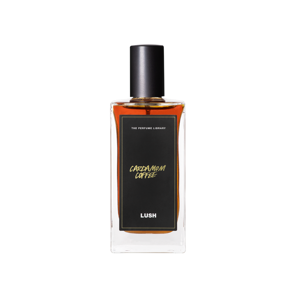 A glass perfume bottle filled with mahogany liquid. A black label reads 'The Perfume Library' and 'Cardamom Coffee'.