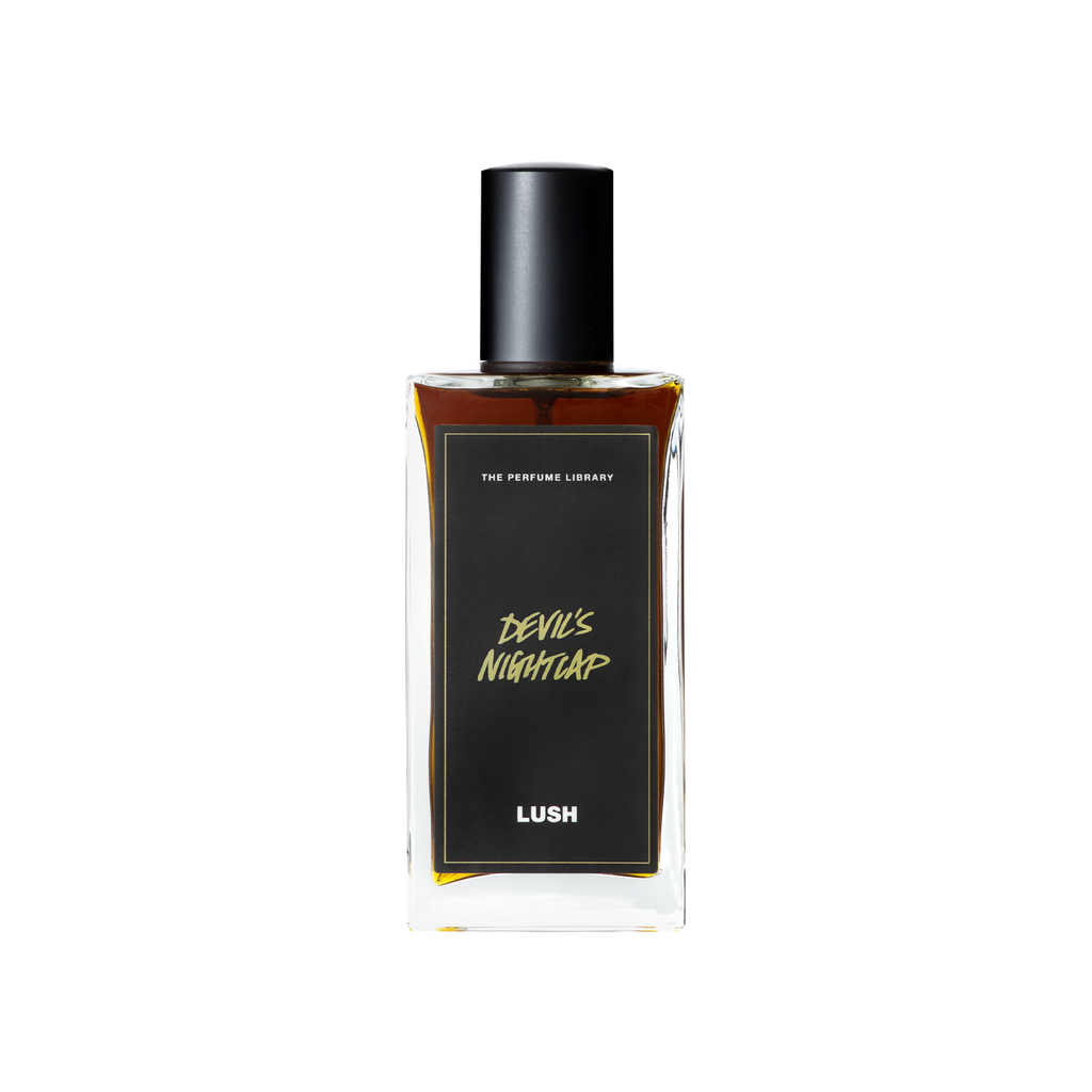 A glass perfume bottle filled with dark mahogany liquid. A black label reads 'The Perfume Library' and 'Devil's Nightcap'.