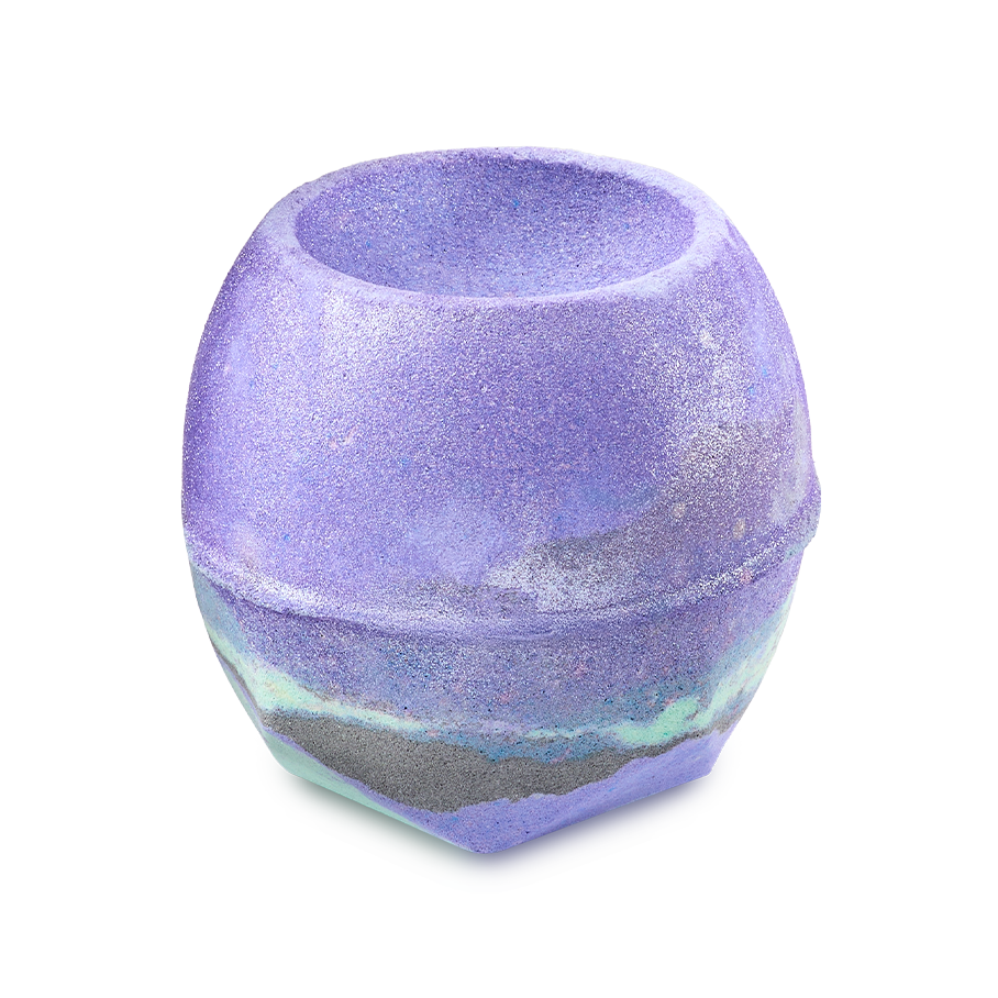 Goddess. A round bath bomb with a bowl-shaped indentation on top. It is primarily vibrant purple with a marbled band of grey and mint green around the base and coated with shimmering silver lustre.