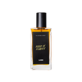A glass perfume bottle filled with dark amber liquid. A black label reads 'The Perfume Library' and 'Keep It Fluffy'.