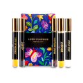 The image shows a "LUSH CLASSICS" perfume gift set. Five thin, cylindrical glass perfume bottles with amber and clear liquids inside are arranged around a dark blue box featuring vibrant floral and butterfly illustrations.