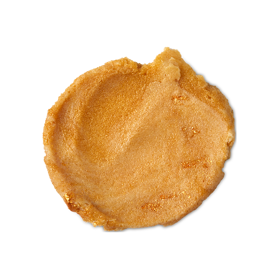 Sticky Dates. A round swatch of thick, golden, exfoliating body scrub with visible sugar granules and gold lustre throughout.